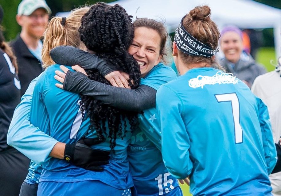 Teammates hugging in celebration at an Ultimate Frisbee tournament