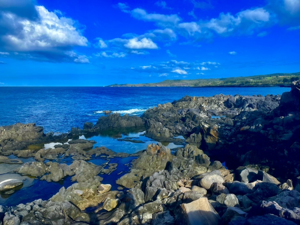 Rocky coastal shoreline beneath a blue sky