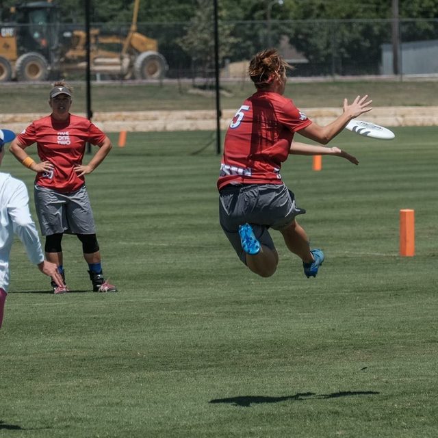 Wendy leaping to catch a disc during an Ultimate Frisbee game