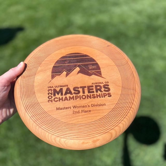 A wooden disc from the 2023 USA Ultimate Masters Championships, Masters Women's Division second place